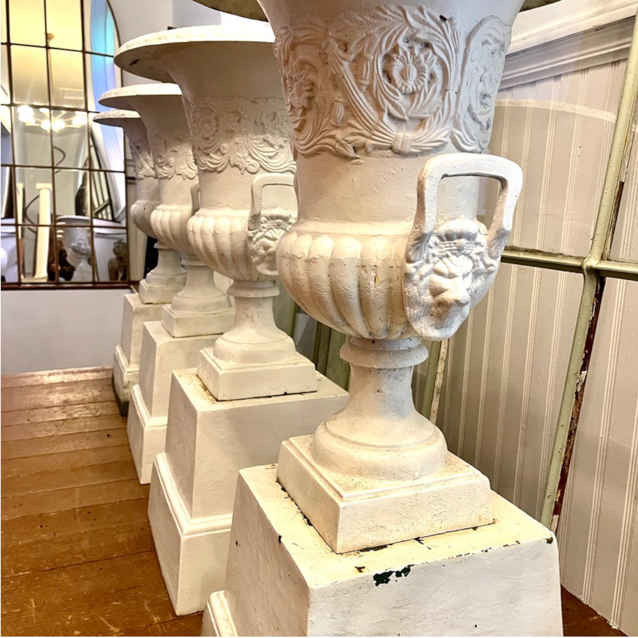 Set of Four Cast Iron Garden Urns with Lion Mask Handles on Plinths